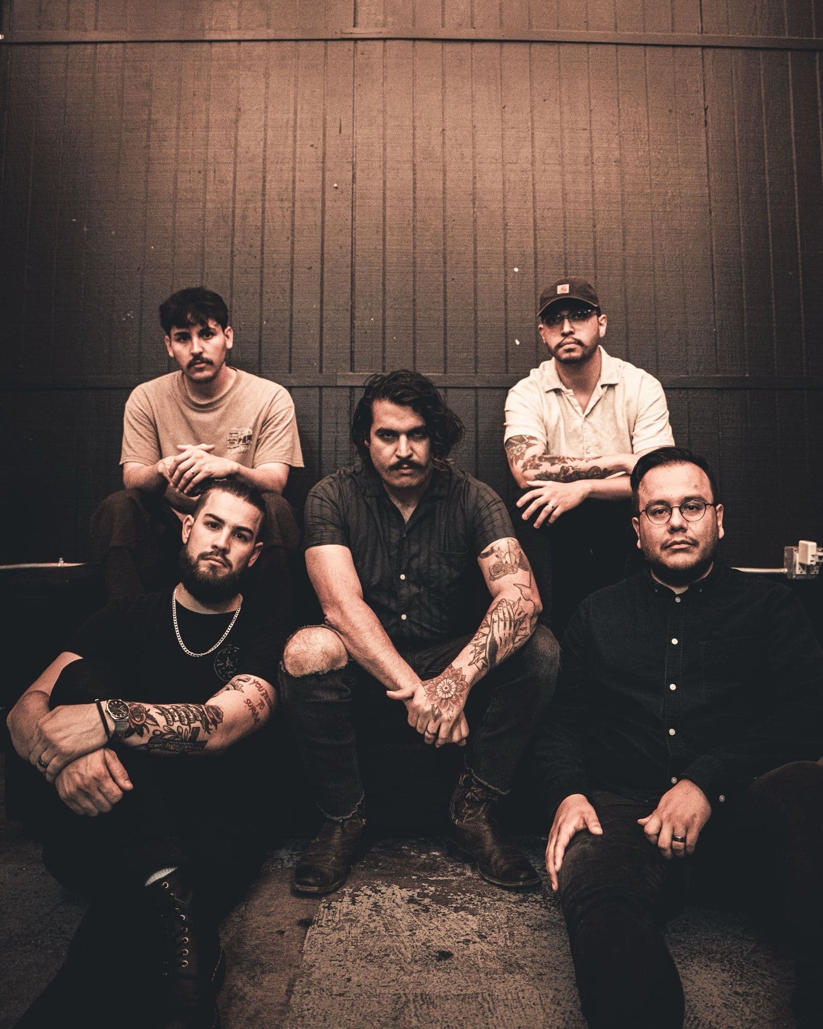 Bloodlines — the five members seated against a wooden wall